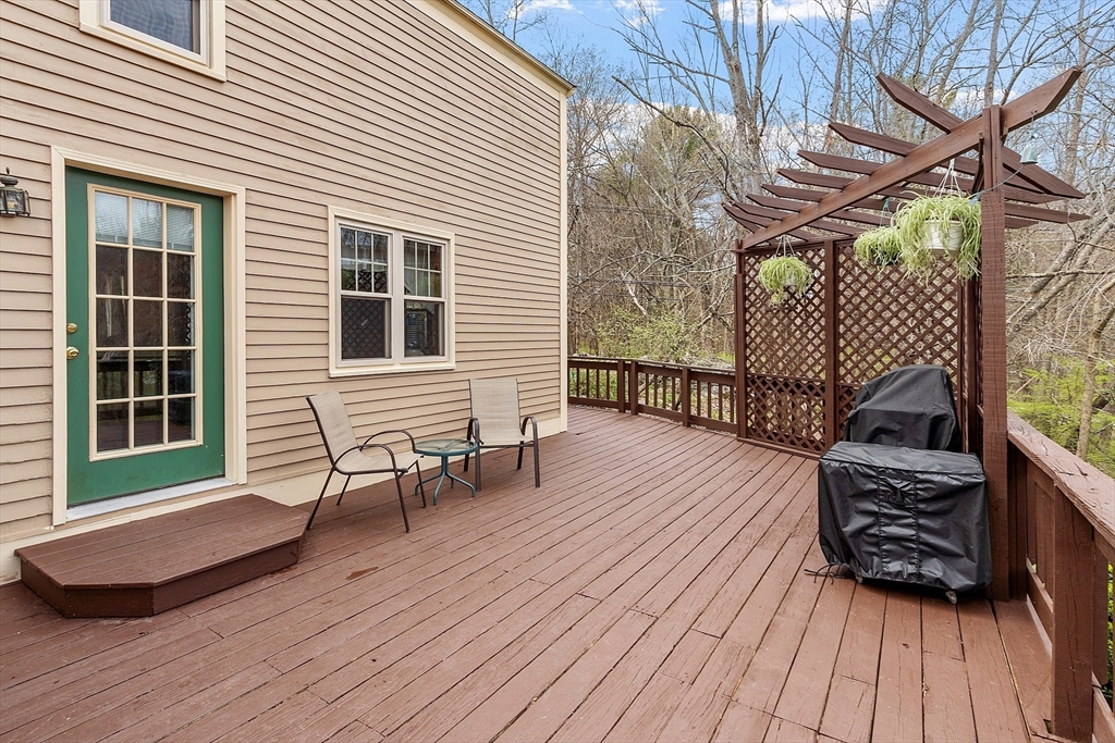 31 Dutton Road Pelham, NH 03076 - Photo 26 of 36 a view of a deck with table and chairs with wooden floor and fence