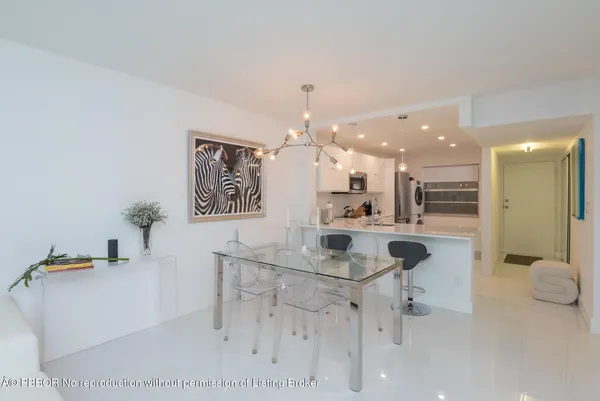 a kitchen with a sink chandelier and living room view