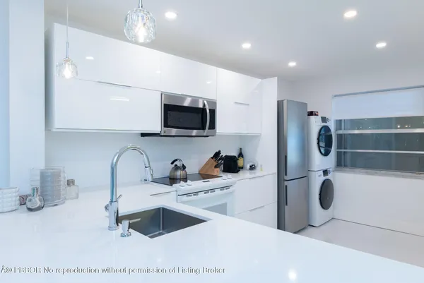 a kitchen with refrigerator a sink and a microwave