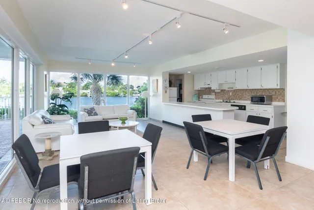 a kitchen with a dining table chairs and white appliances