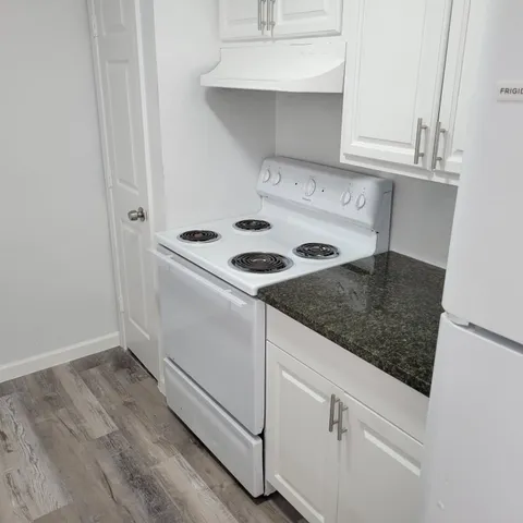 a kitchen with white cabinets and white appliances