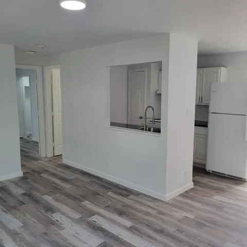 a view of an empty room with closet and a window