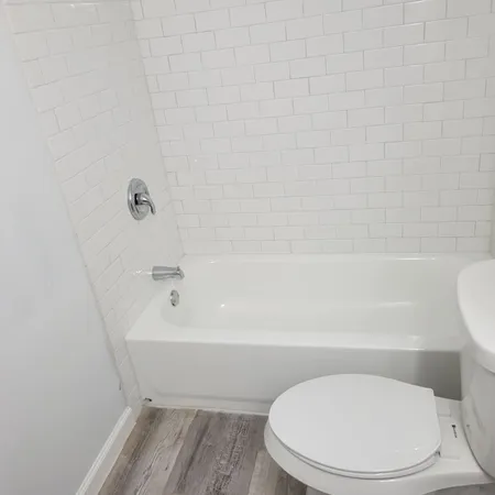 a white toilet sitting next to a bath tub