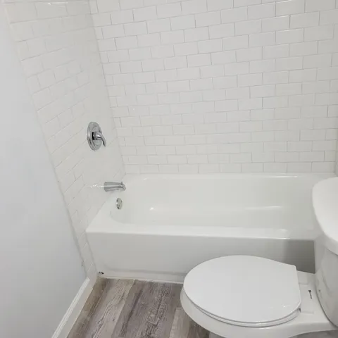 a white toilet sitting next to a bath tub