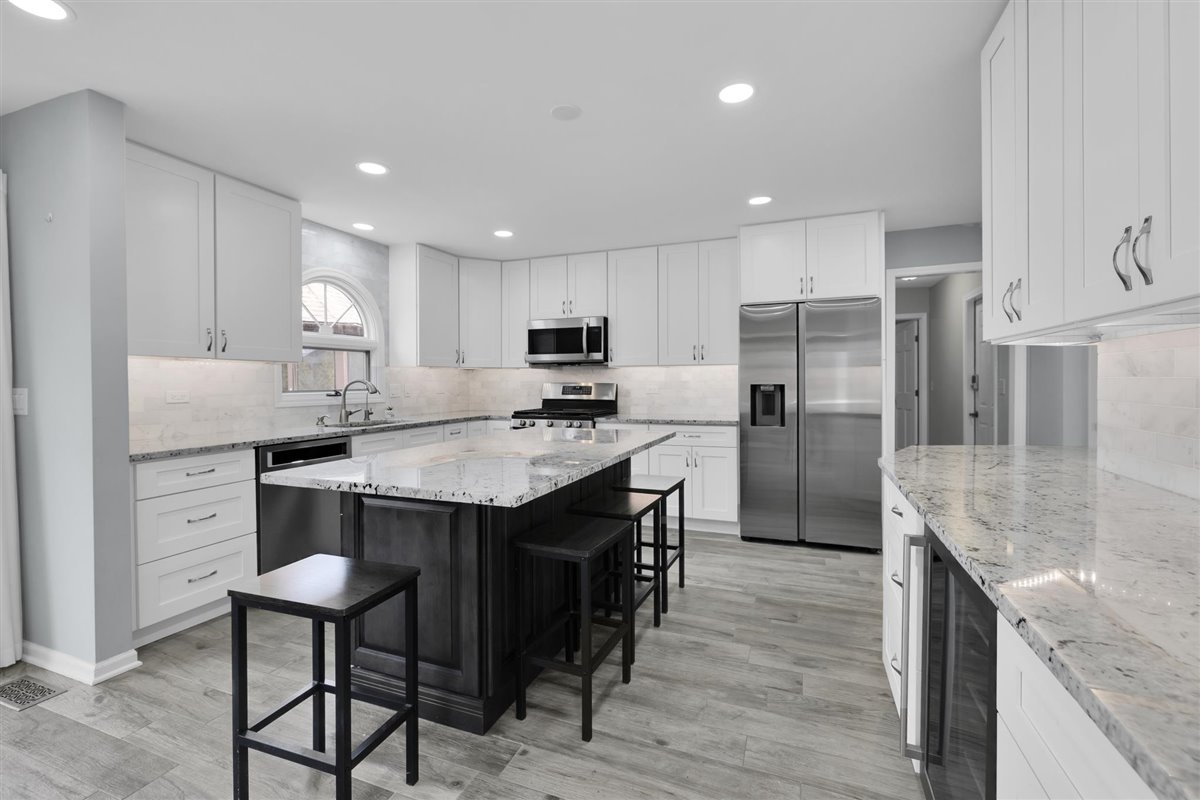 607 Cottage Road Batavia, IL 60510 - Photo 7 of 36 a kitchen with kitchen island granite countertop wooden floor cabinets and stainless steel appliances
