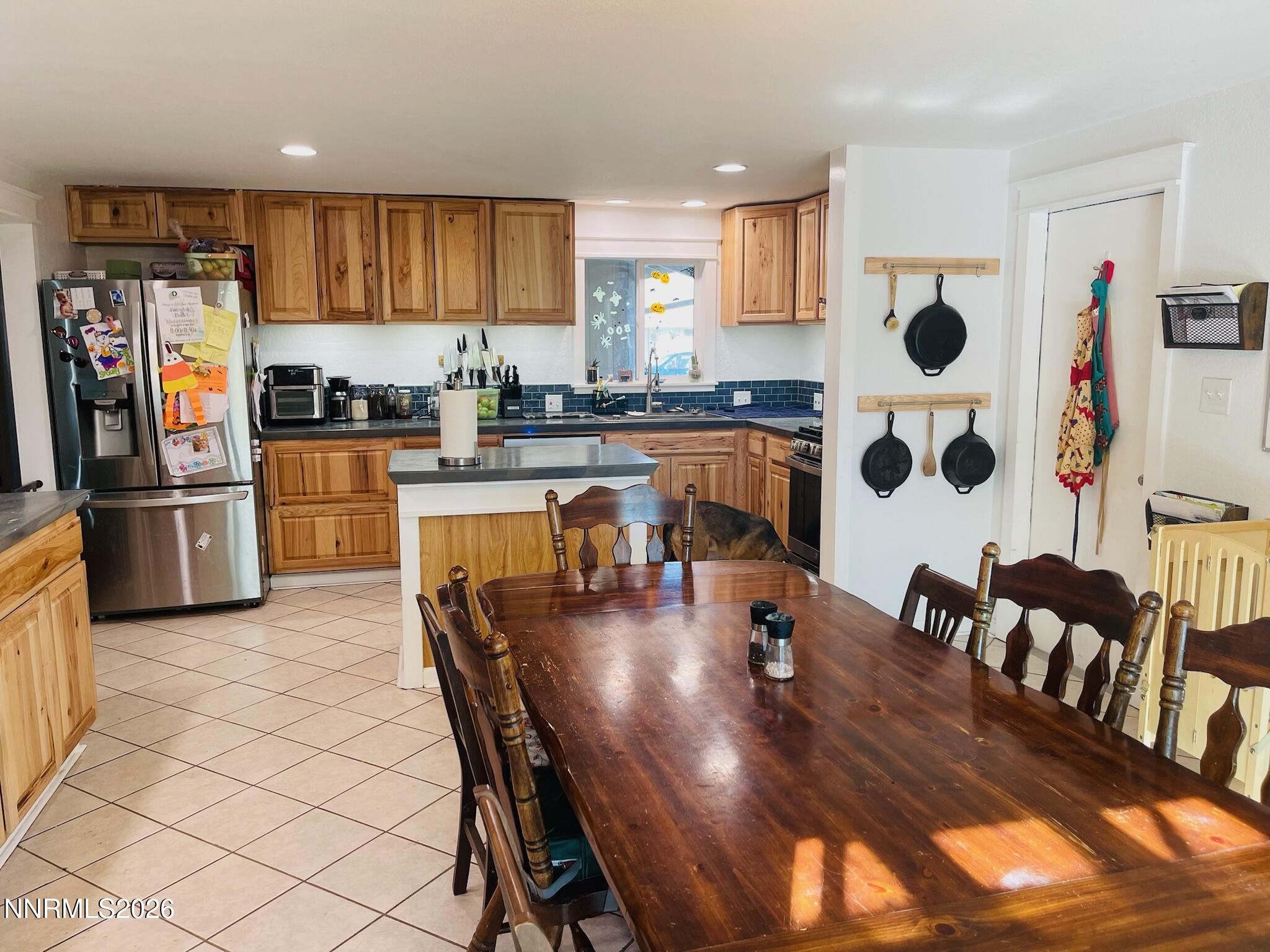 334 Kay Way Yerington, NV 89447 - Photo 9 of 22 a kitchen with stainless steel appliances granite countertop a refrigerator a stove a sink a dining table and chairs with wooden floor