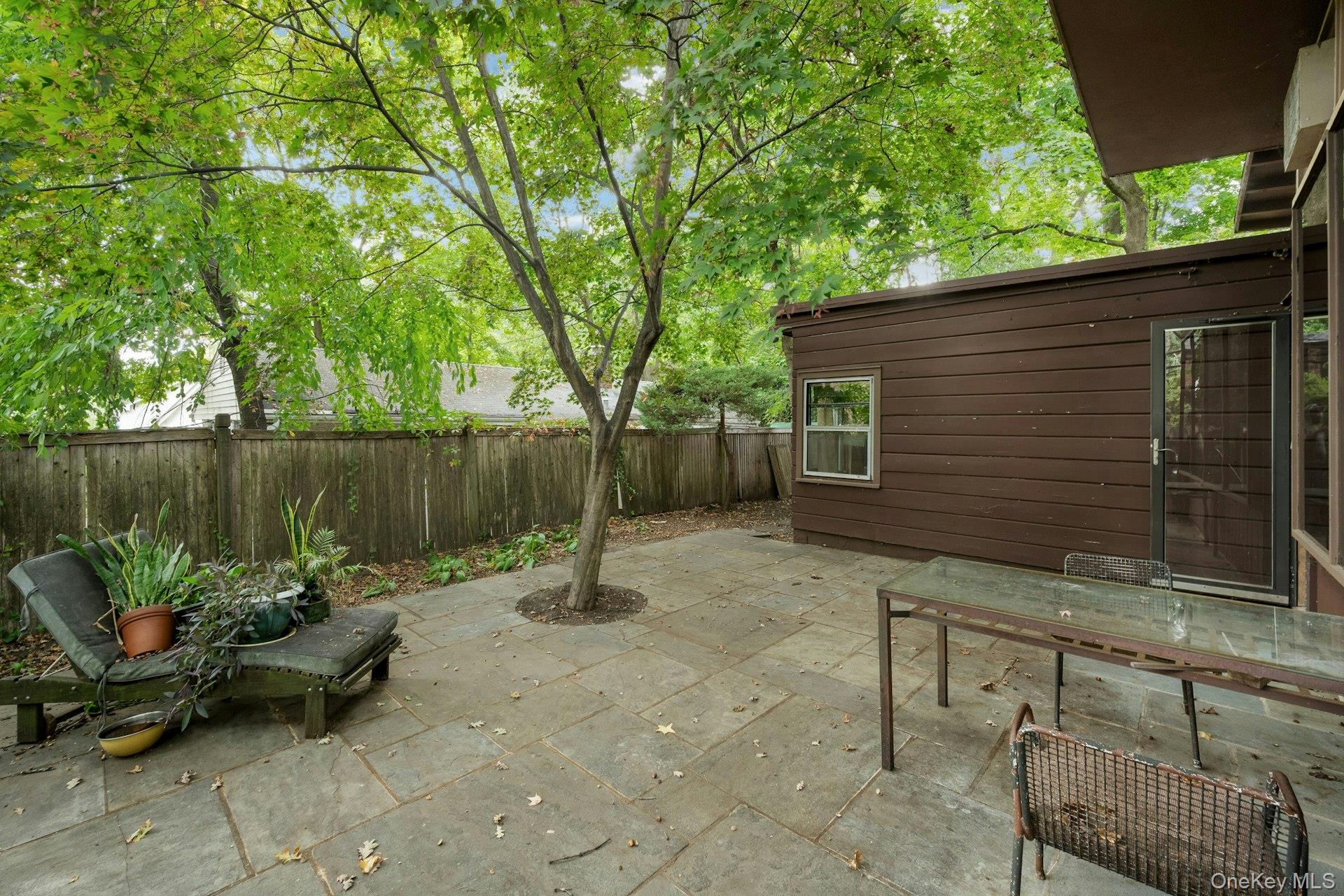 a backyard of a house with barbeque oven table and chairs
