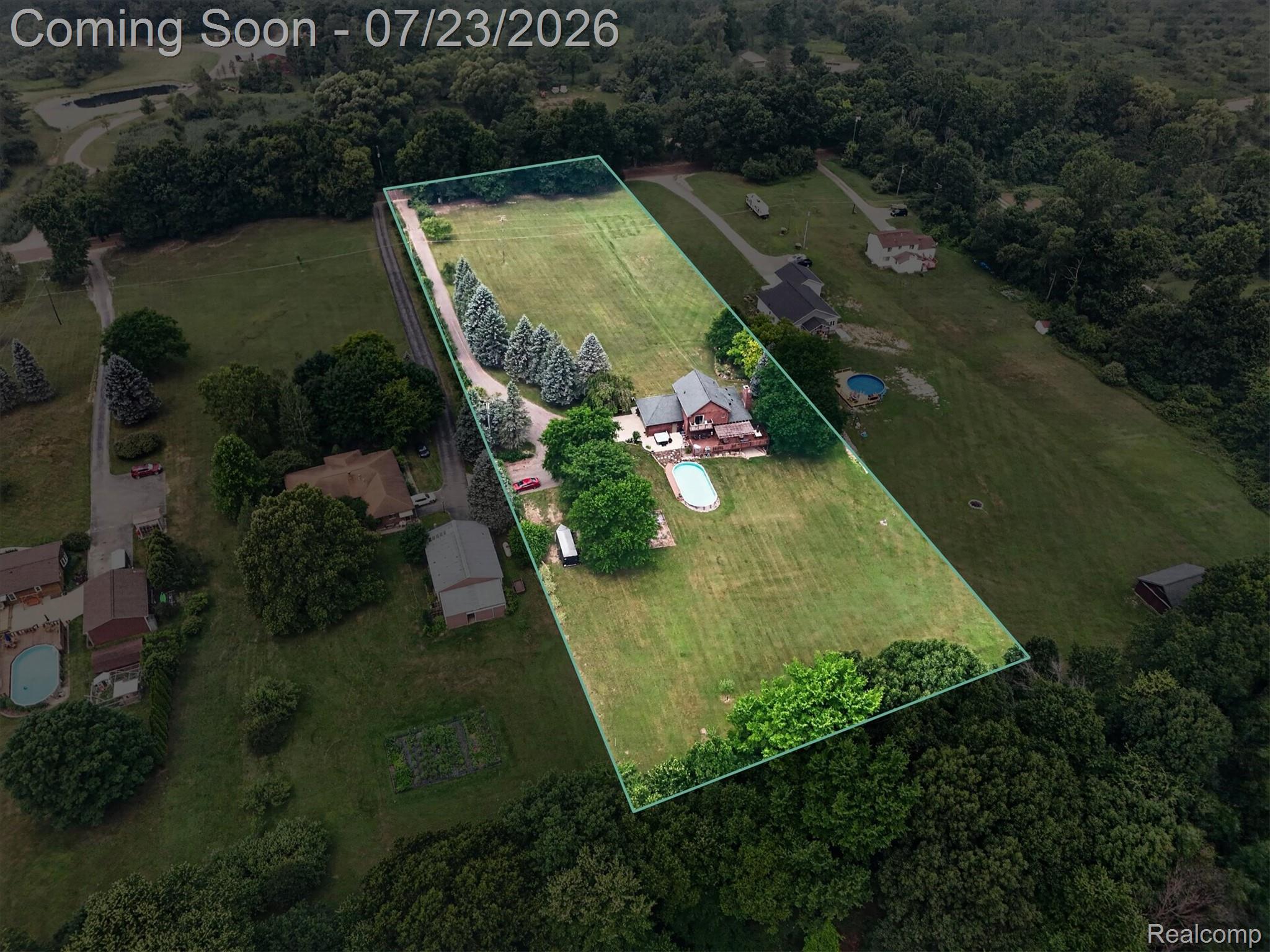 2795 Bird Road Ortonville, MI 48462 - Photo 60 of 62 Expansive property featuring a main residence with a large backyard, an in-ground swimming pool, a separate outbuilding, and a lengthy driveway lined with evergreen trees