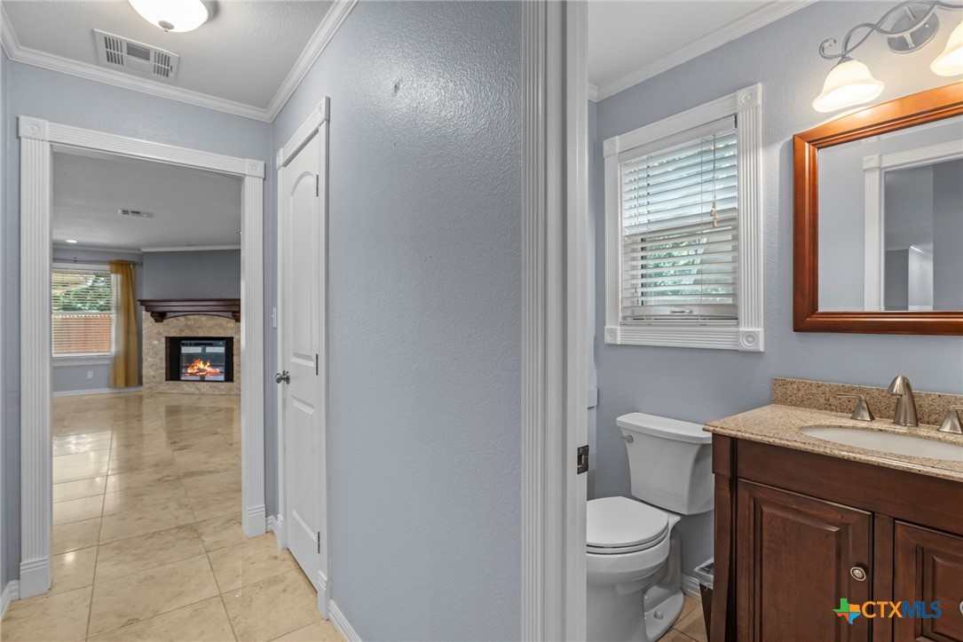 3745-3735 Canyon Heights Road Belton, TX 76513 - Photo 24 of 33 a bathroom with a granite countertop toilet a sink and a mirror