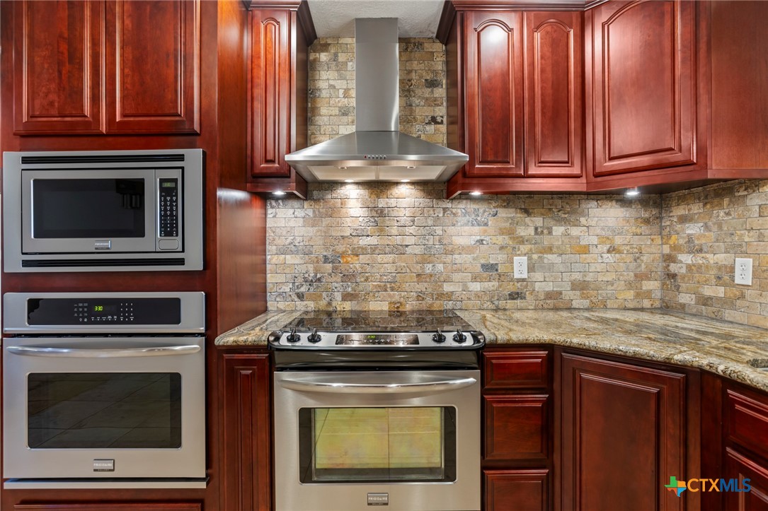 3745-3735 Canyon Heights Road Belton, TX 76513 - Photo 8 of 33 a stove top oven sitting inside of a kitchen and granite counter tops