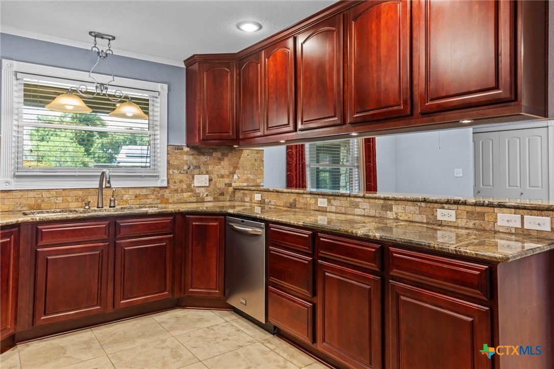 3745-3735 Canyon Heights Road Belton, TX 76513 - Photo 10 of 33 a kitchen with stainless steel appliances granite countertop wooden cabinets a sink and dishwasher with wooden floor