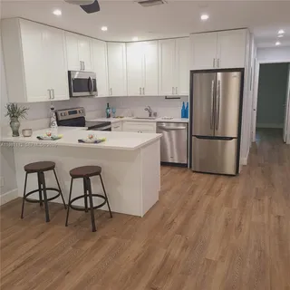 a kitchen with stainless steel appliances a refrigerator stove microwave and white cabinets