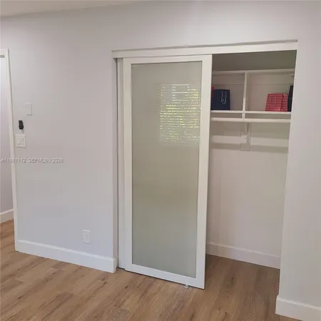 an empty room with wooden floor and a window