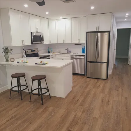 a kitchen with stainless steel appliances a refrigerator stove microwave and white cabinets