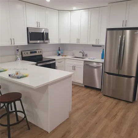 a kitchen with stainless steel appliances a refrigerator stove microwave and sink