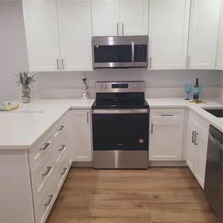a kitchen with stainless steel appliances a stove a sink and a microwave