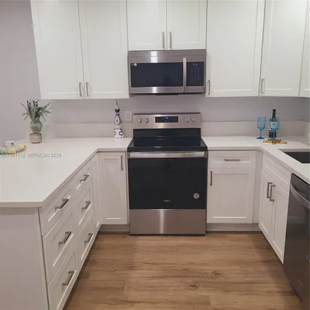 a kitchen with stainless steel appliances a stove a sink and a microwave
