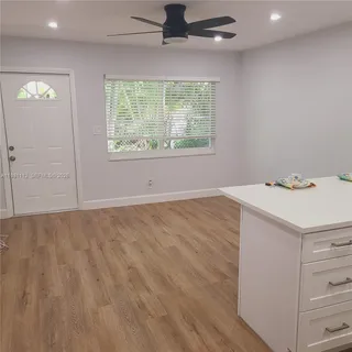 an empty room with a window and a ceiling fan