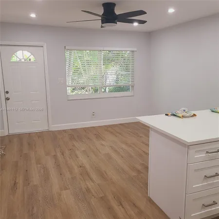 an empty room with a window and a ceiling fan