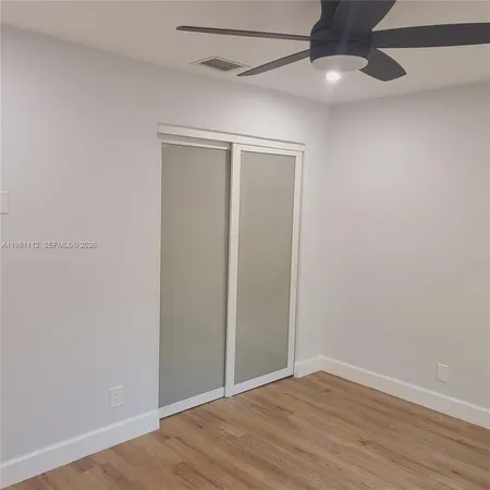 a view of empty room with wooden floor