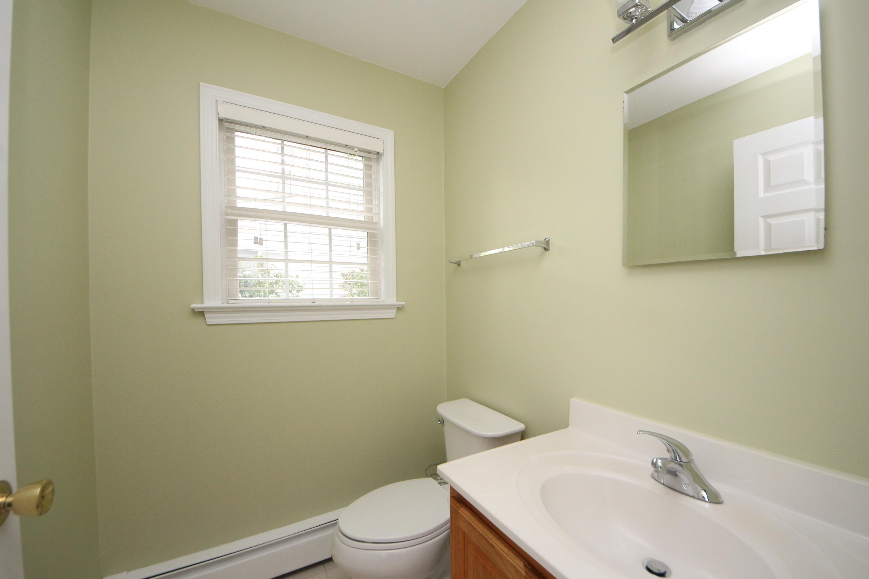 189 Hollow Tree Ridge Road Darien, CT 06820 - Photo 14 of 27 a bathroom with a sink a toilet and a window