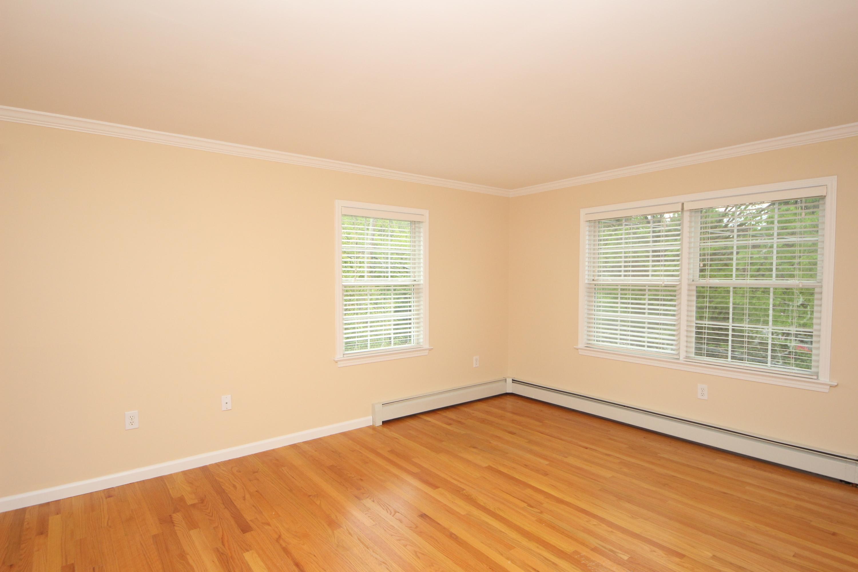 189 Hollow Tree Ridge Road Darien, CT 06820 - Photo 17 of 27 an empty room with wooden floor and windows