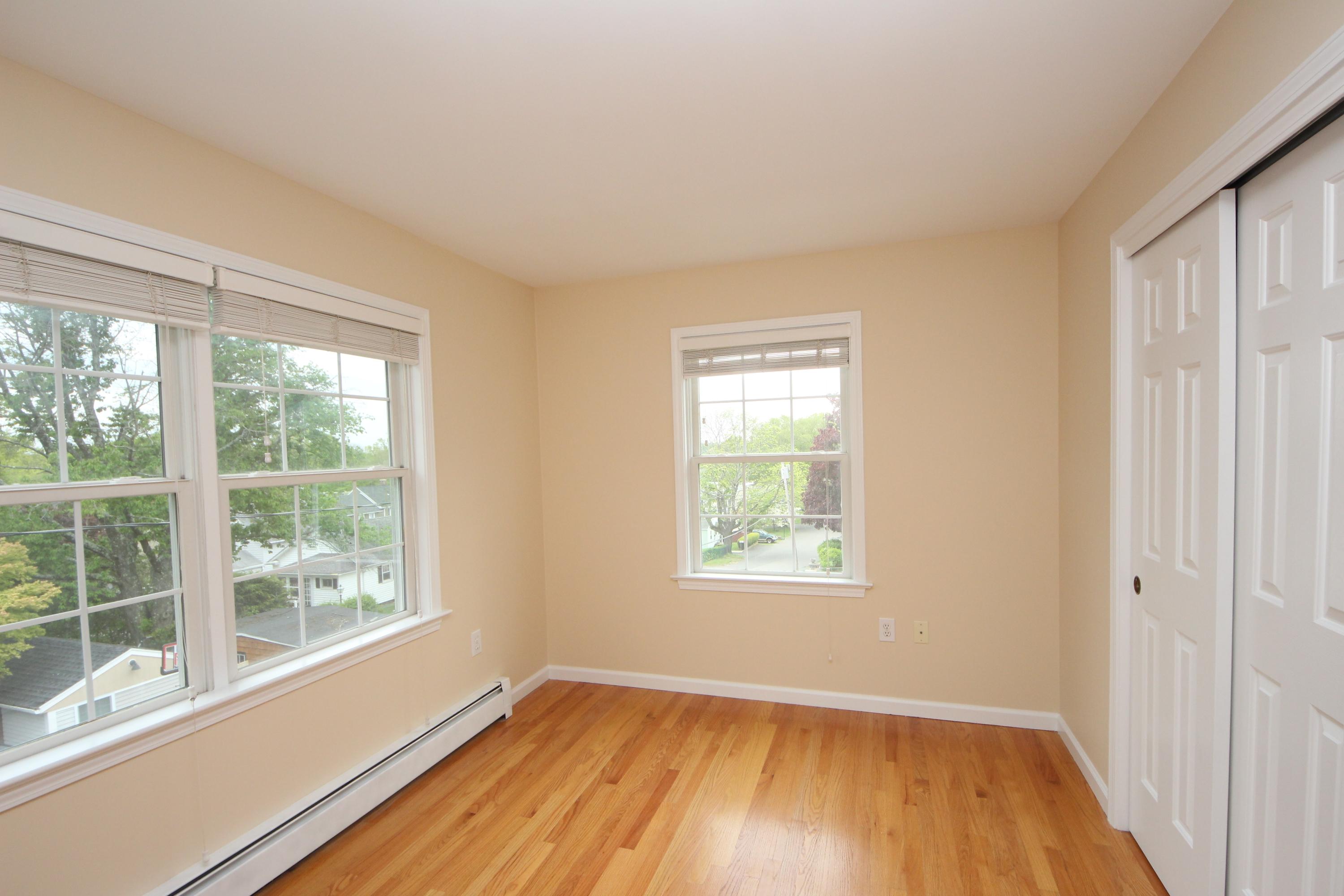189 Hollow Tree Ridge Road Darien, CT 06820 - Photo 21 of 27 an empty room with wooden floor and windows