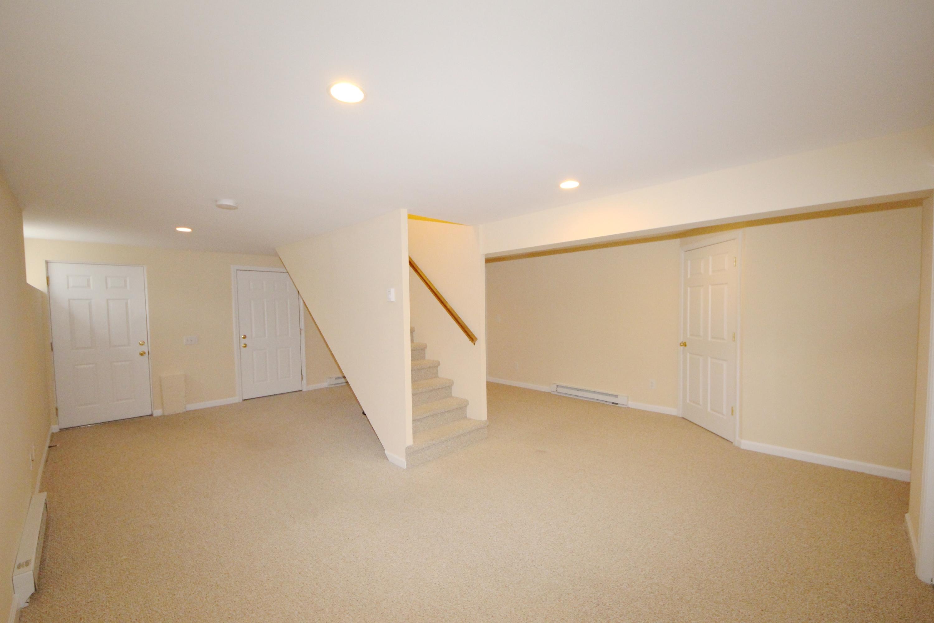 189 Hollow Tree Ridge Road Darien, CT 06820 - Photo 27 of 27 an empty room with stairs and white walls