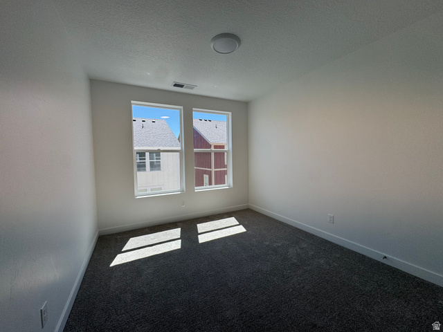 1476 North 1875 West, Unit 152 Layton, UT 84041 - Photo 11 of 20 Bright interior room with two large windows, white walls, and dark gray carpet flooring