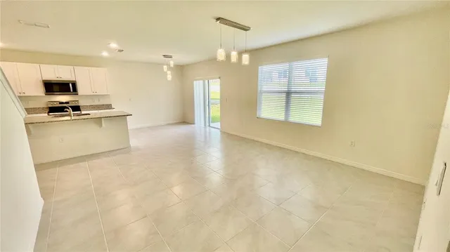 a view of kitchen with kitchen island a sink wooden floor and a refrigerator