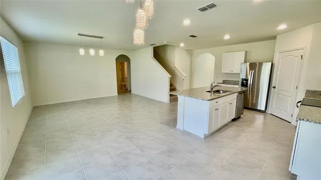a view of a kitchen with stainless steel appliances granite countertop a stove and a refrigerator