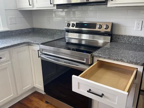 a stove top oven sitting inside of a kitchen
