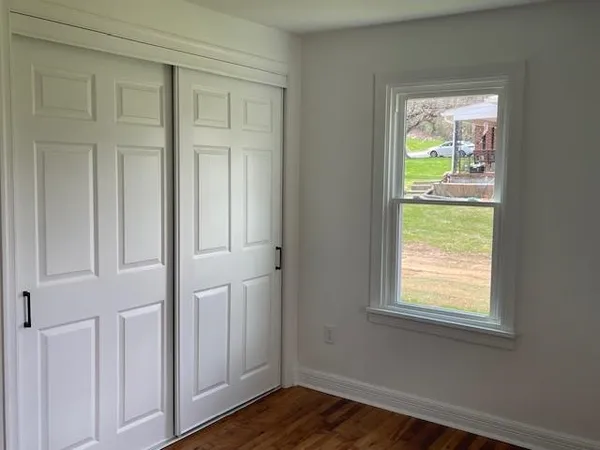 a view of an entryway with wooden floor and front door