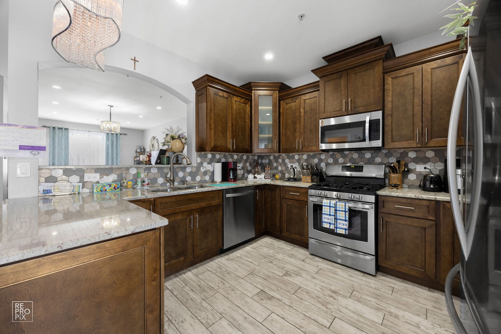 7504 Claridge Drive, Unit E Bridgeview, IL 60455 - Photo 8 of 25 a kitchen with stainless steel appliances granite countertop a sink refrigerator stove and microwave