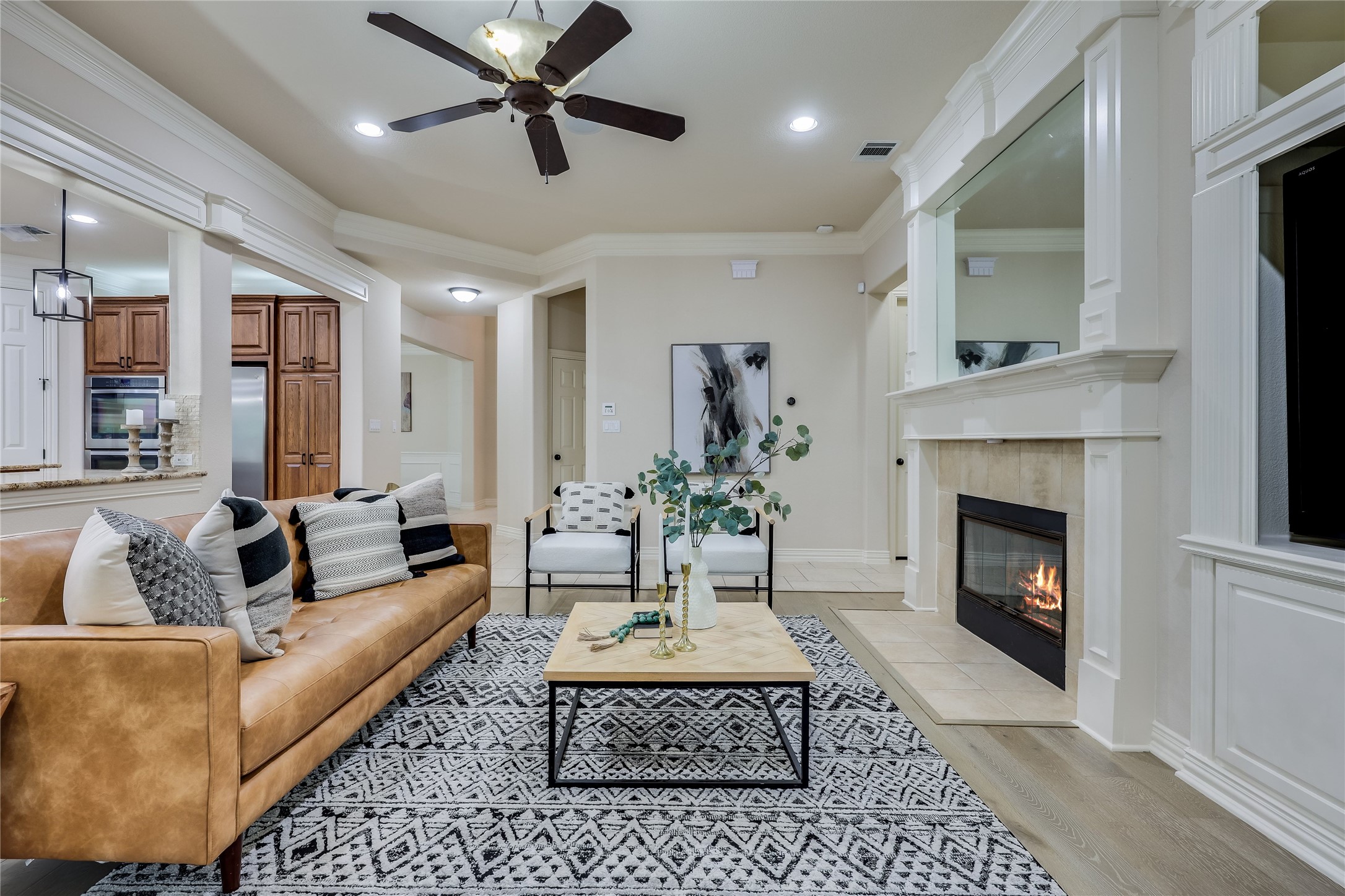 408 Ridgetop Bend Cedar Park, TX 78613 - Photo 7 of 40 A well-appointed living area features a warm fireplace and seamless access to the kitchen.