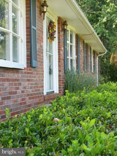 7218 Wilson Road Marshall, VA 20115 - Photo 23 of 30 a view of a brick house with a large windows and flower plants
