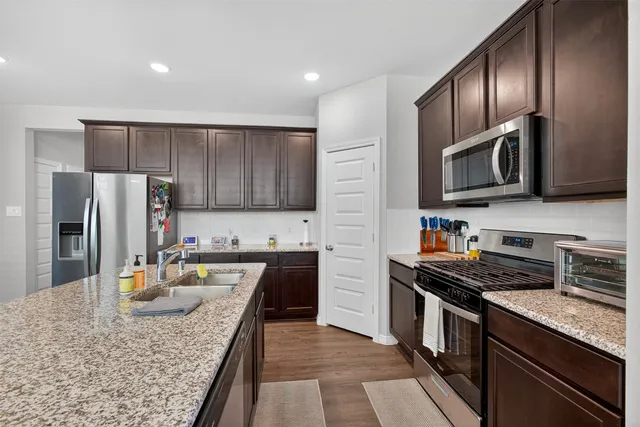 a kitchen with granite countertop stainless steel appliances and wooden cabinets