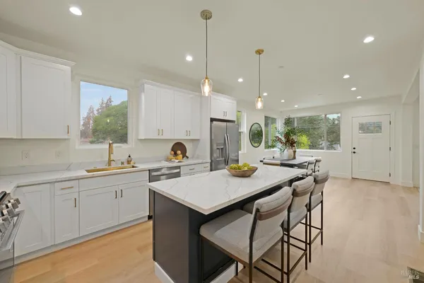 a kitchen with a table chairs sink and cabinets