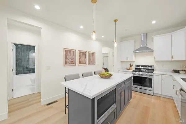 a kitchen that has a lot of cabinets in it and wooden floors