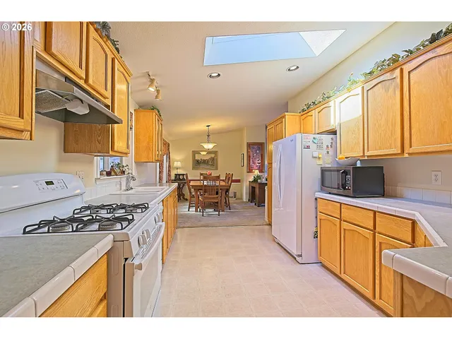 a kitchen with stainless steel appliances a stove a sink a refrigerator and furniture