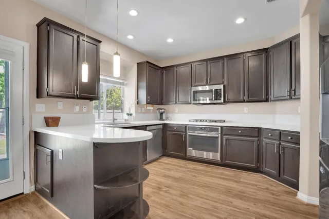 a kitchen with kitchen island granite countertop wooden cabinets and stainless steel appliances