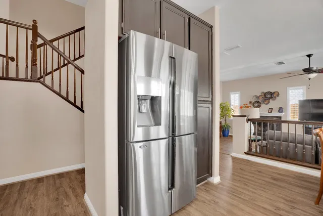 a kitchen with stainless steel appliances a refrigerator and wooden floor