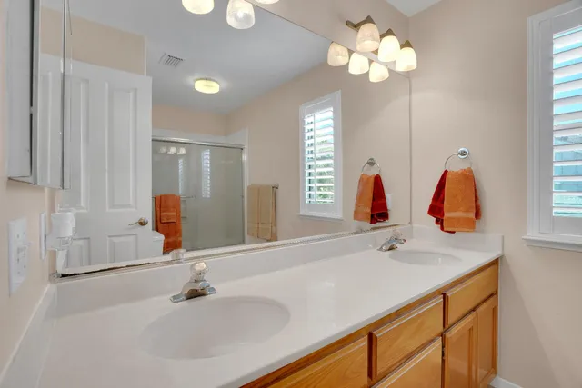 a bathroom with a double vanity sink and a mirror