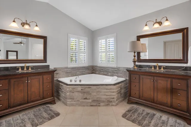a spacious bathroom with a granite countertop tub sink and mirror