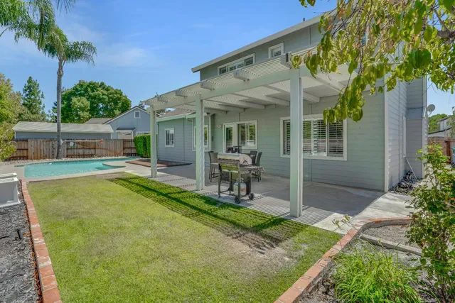 a view of a house with pool and chairs
