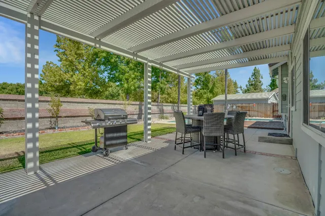 a view of a patio with table and chairs next to a yard