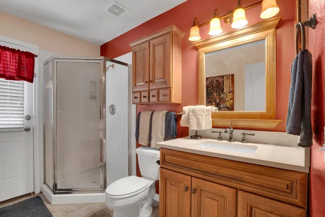 a bathroom with a sink a toilet a mirror and shower