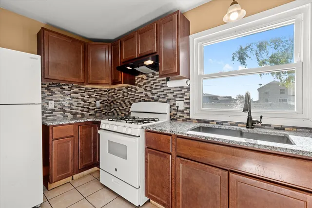 a kitchen with stainless steel appliances granite countertop a sink stove and cabinets