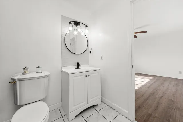 a bathroom with a toilet a sink and mirror