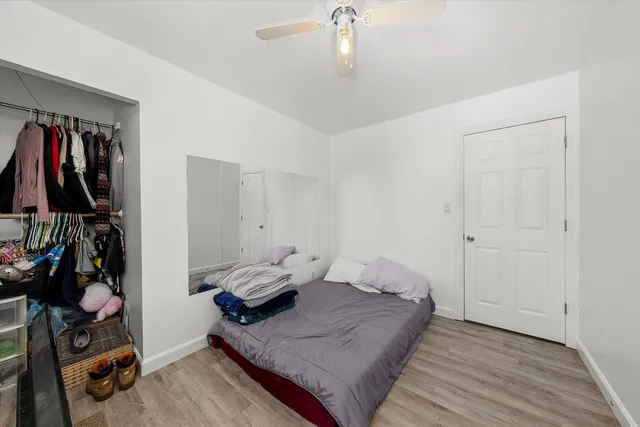 a view of empty room with wooden floor and fan